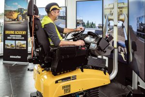 Ein Schulungsteilnehmer erlernt das Bedienen der Baumaschine mit Hilfe des Komatsu-Fahrsimulators.