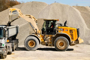 Caterpillar Radlader, ausgerüstet mit neuen Assistenzsystemen, beim Beladen eines Lkw mit Sand.