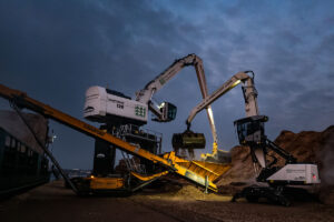 Mantsinen 120R und zwei Fuchs MHL340F stemmen Holzumschlag