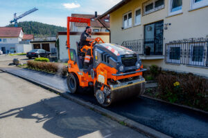 Vögele MINI 502e Fertiger und Hamm HD 12e VT Walze im vollelektrischen Asphalteinbau