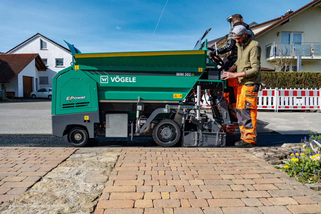 Vögele MINI 502e Fertiger und Hamm HD 12e VT Walze im vollelektrischen Asphalteinbau