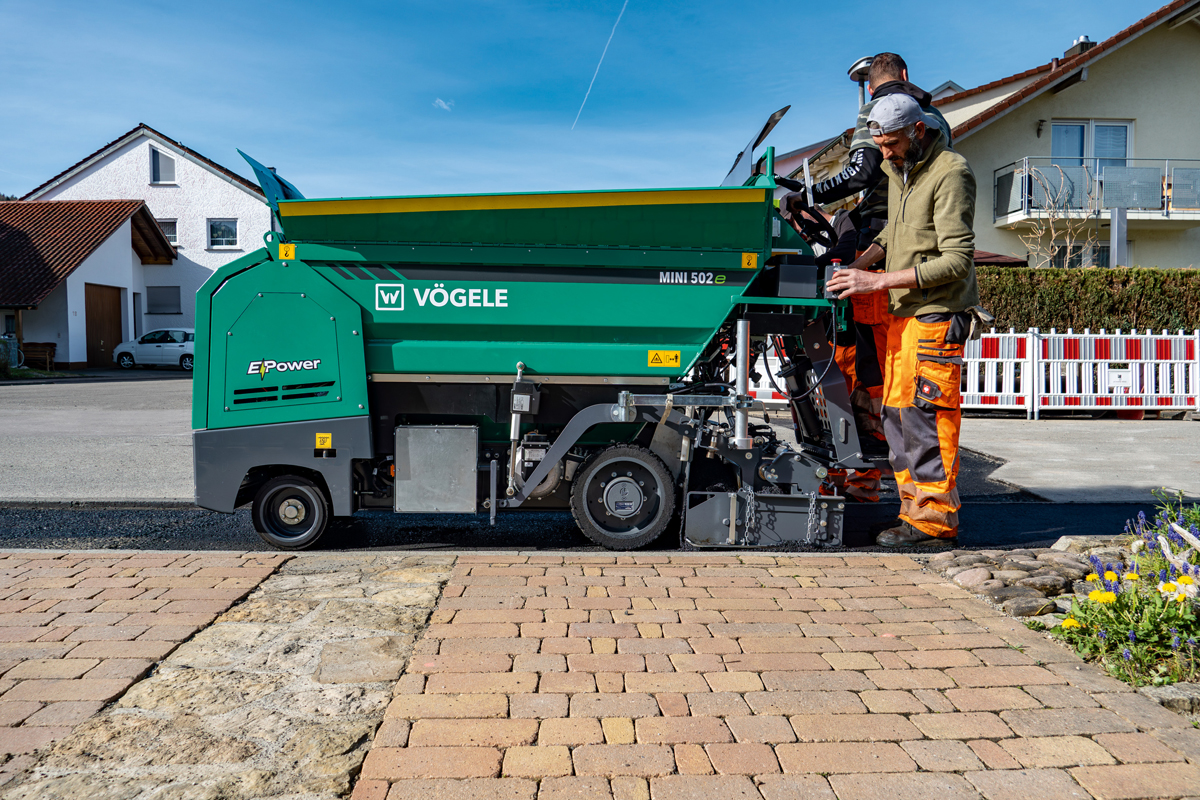 Vögele MINI 502e Fertiger und Hamm HD 12e VT Walze im vollelektrischen Asphalteinbau
